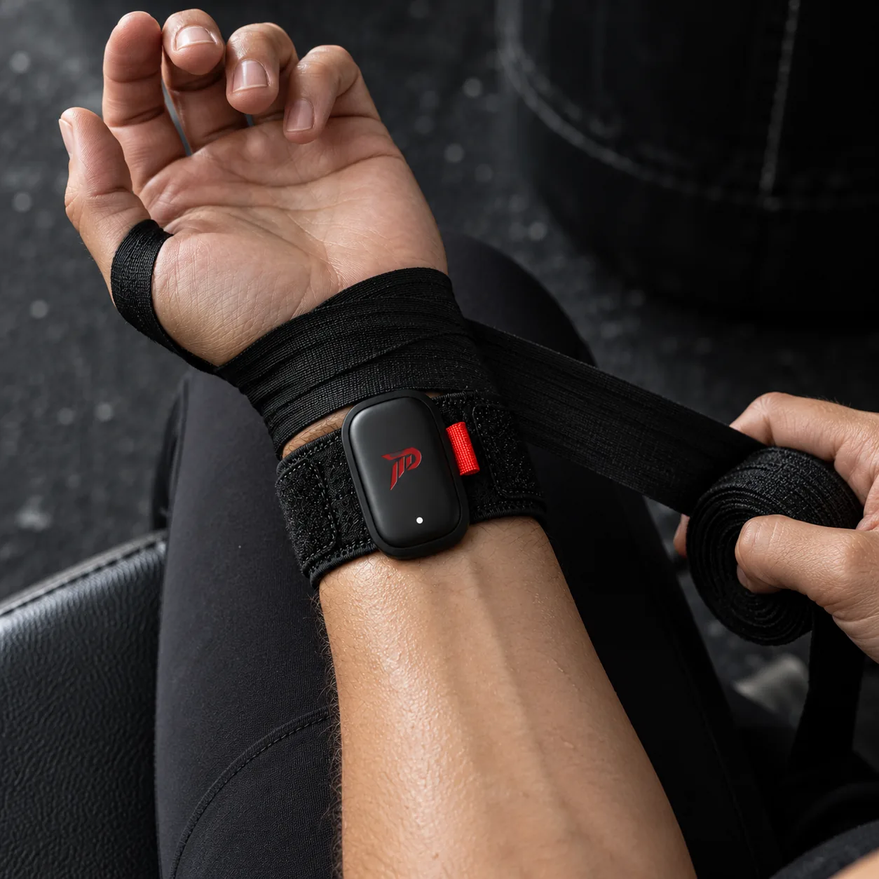 The PUMNO band and sensor on the palm side of the wrist, with the first layer of hand wrap going over it.